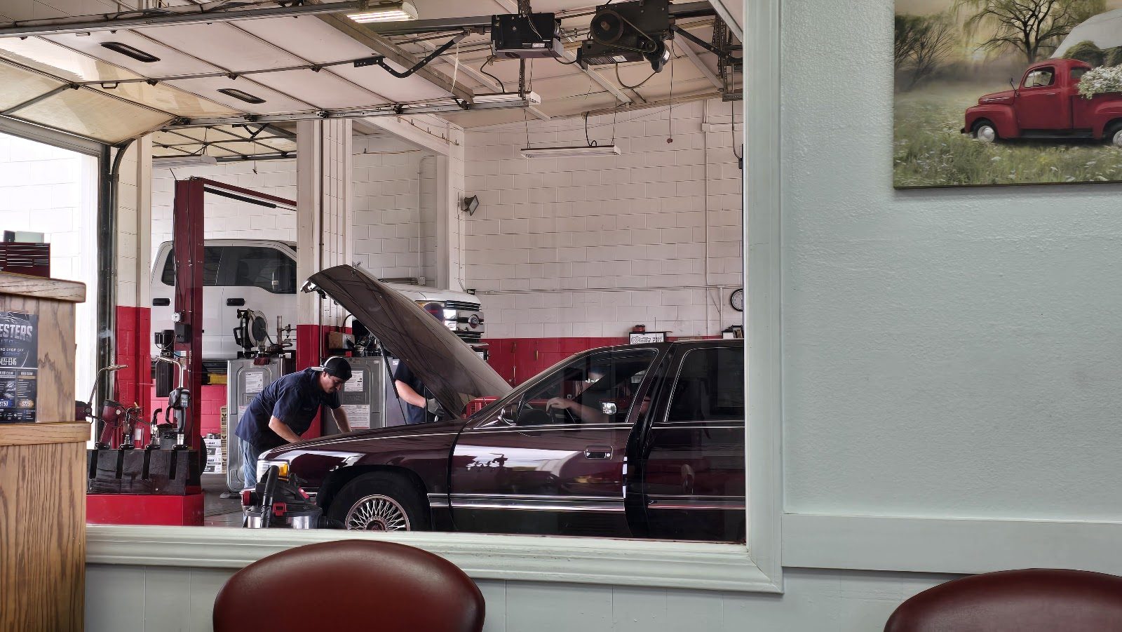 Mechanics at work in Barney's service bay, seen from the waiting room